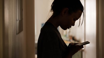 Behavioral addiction: silhouette of girl on mobile phone 1271381289