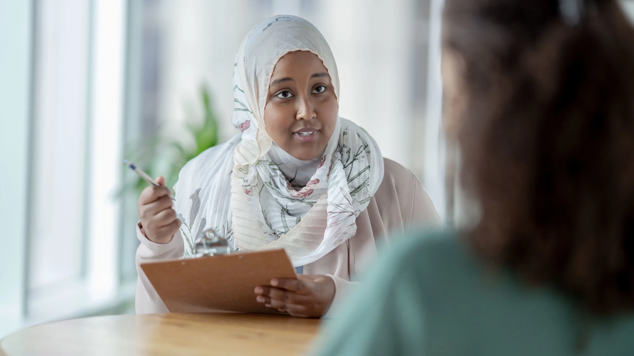 A therapist talking to a client and taking notes. 