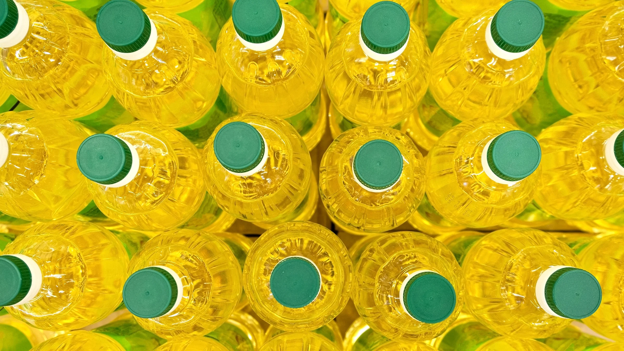 A top view shows a number of bottles of cooking oil with green caps.
