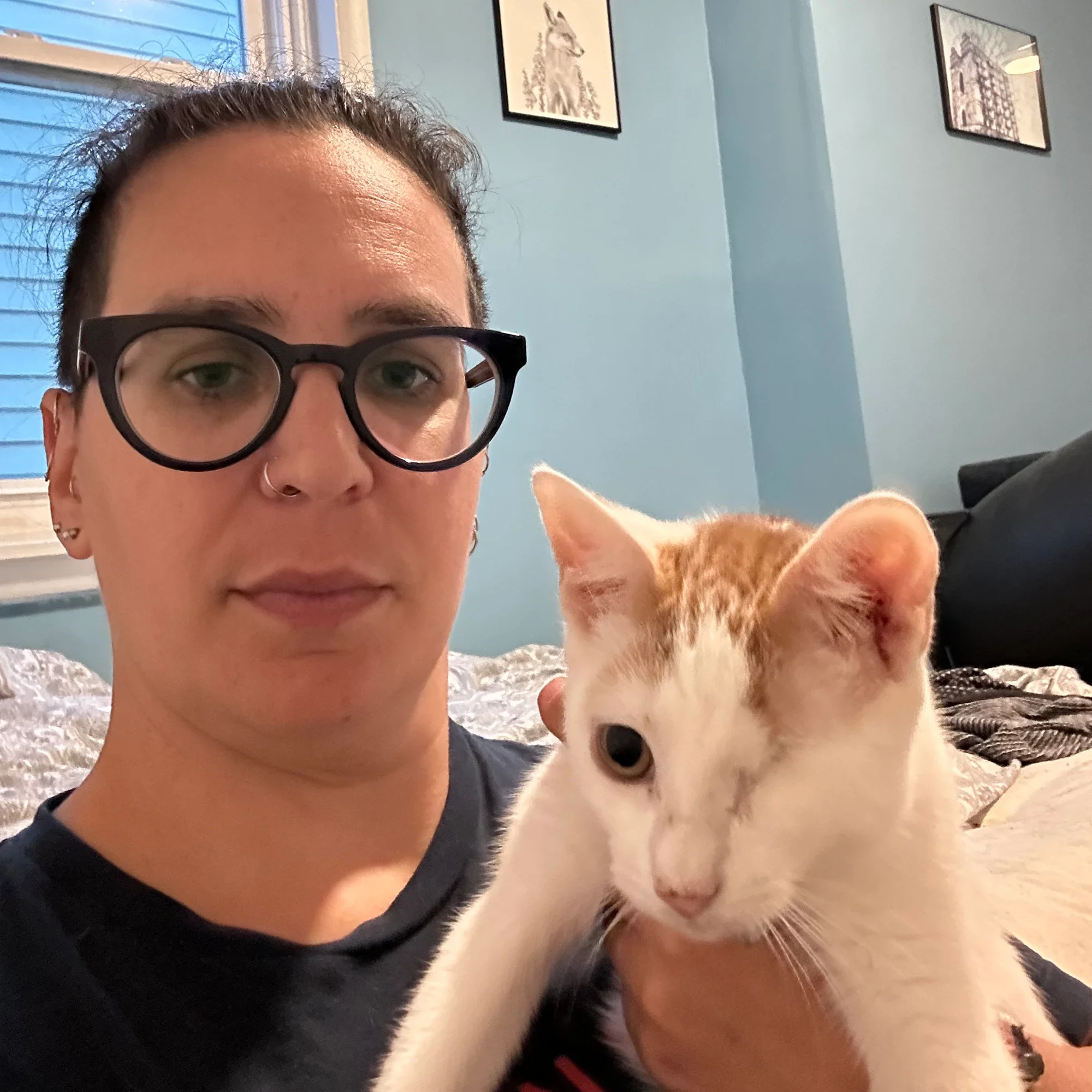 Photo of Em with one of her foster cats with one eye.