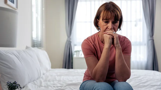 Anxiety: anxious woman sitting on a bed 1472728023