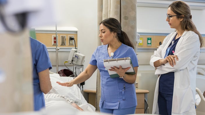 Medical professionals speaking to a surgical patient.