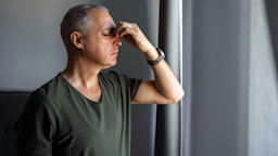 A man pinches the bridge of his nose as he deals with sinus pain.
ljubaphoto/E+ via Getty Images 
