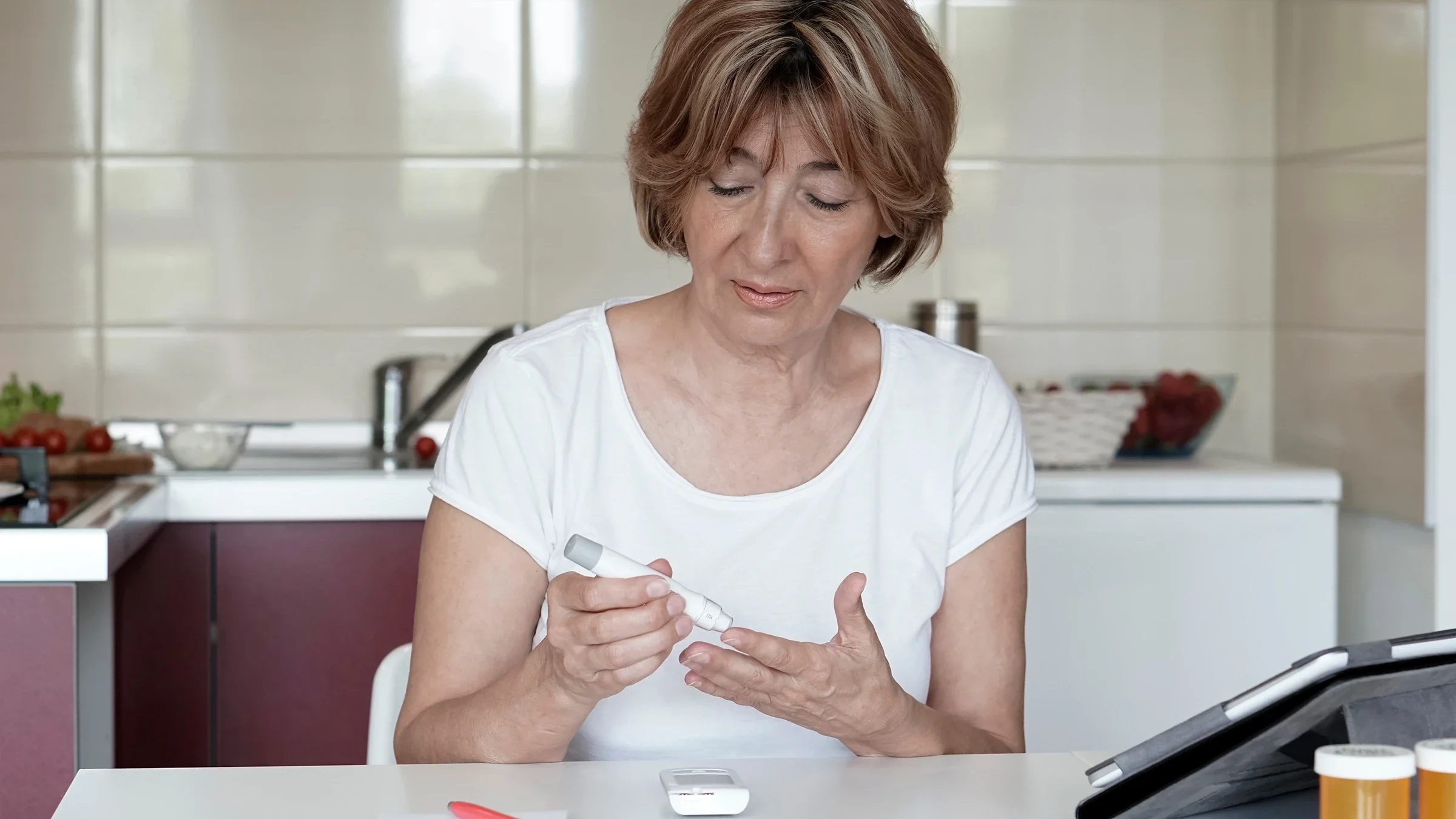 A woman is testing her blood sugar levels at home.