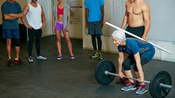 Movement-exercise: senior woman doing barbell exercise 512102548