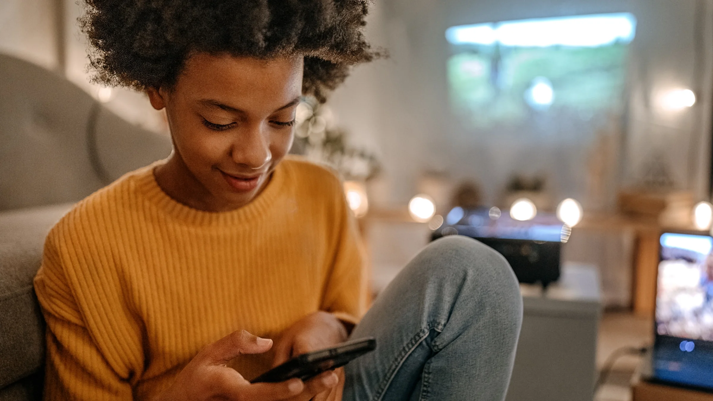 Young, teen girl using her mobile phone at home.