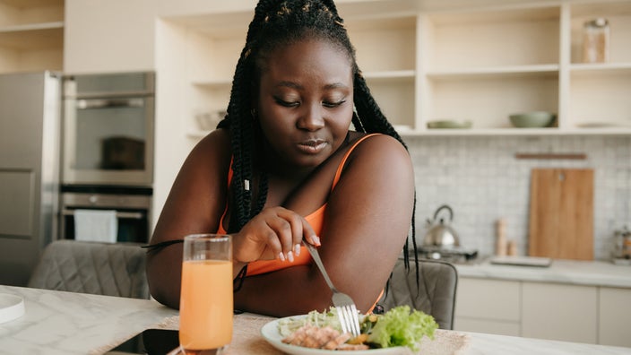 Woman enjoying healthy food for lunch at home.