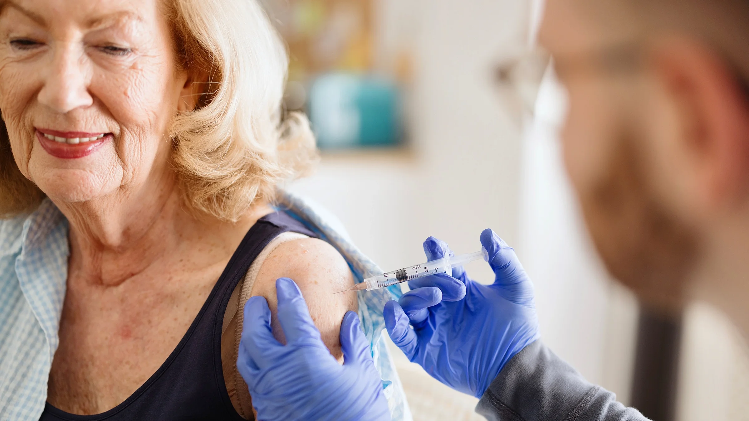 A close-up of an older woman receiving a vaccine.