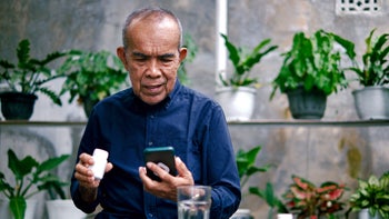 Medication Education: Pharmacy: man researching medication on smart phone 1426188001