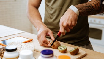 Constipation: closeup man cutting kiwi 1143103444