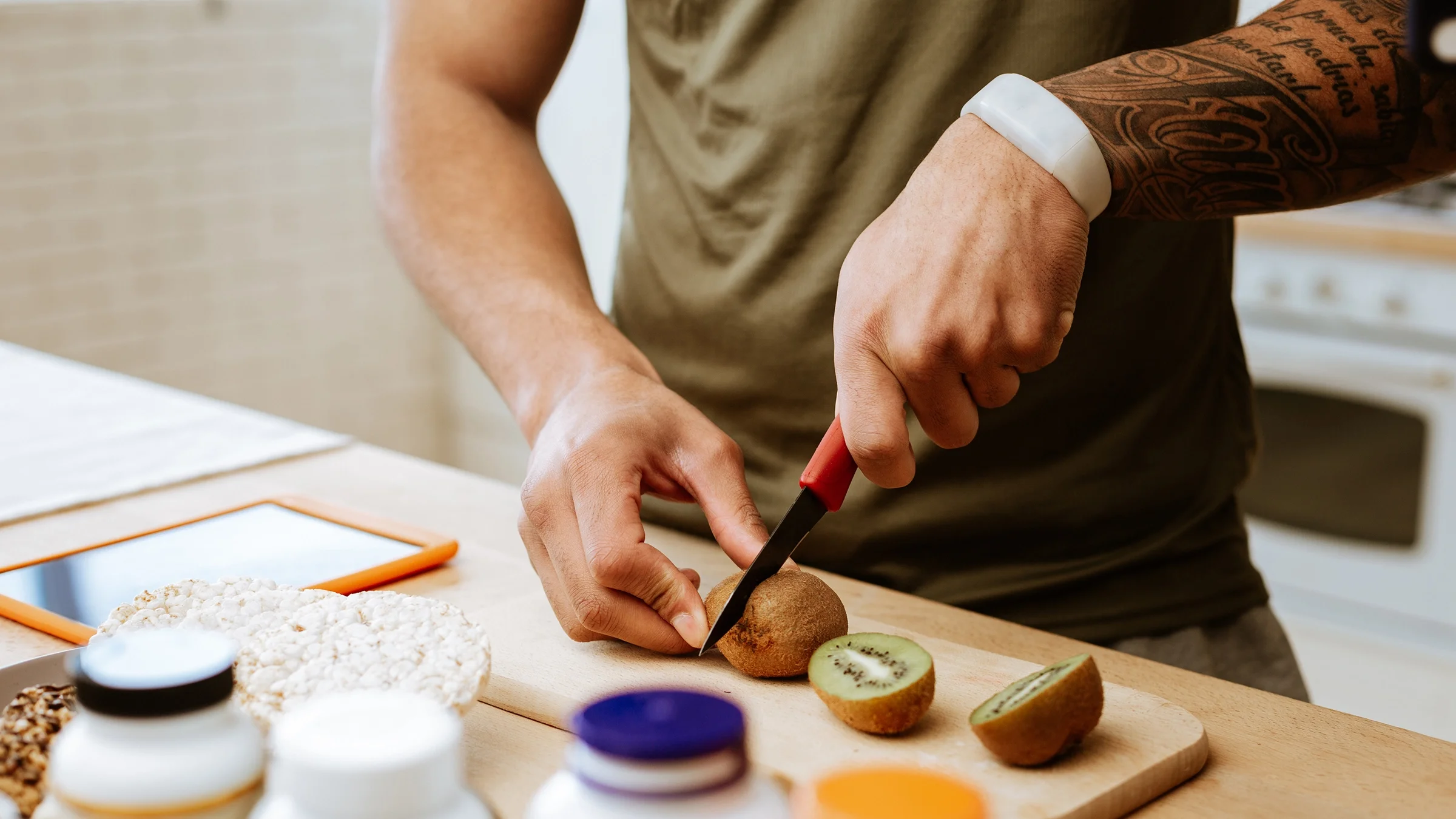 Close-up man cutting a kiwi.
