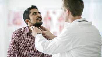 Thyroid: Hypothyroidism: doctor checking mans thyroid 607768032
