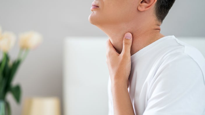 Close-up hand on throat.