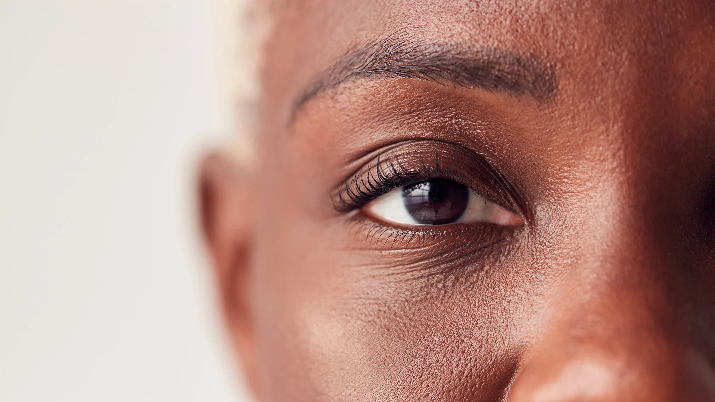 Close-up on a woman's eye. The background is plain white.
monkeybusinessimages/iStock via Getty Images
