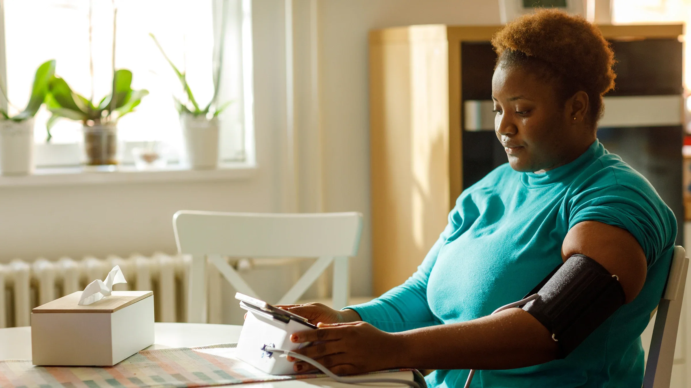 A woman checks her blood pressure at home.
vgajic/E+ via Getty Images 