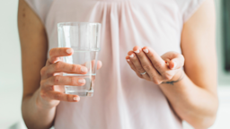 A sick person taking medicine in bed.
Ziga Plahutar/iStock via Getty Images Plus