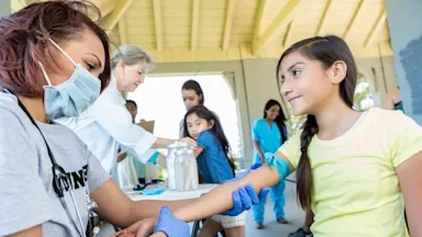 Free low-cost healthcare: outdoor free clinic doctor and child 610977488