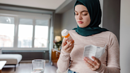 A woman reads the the label of her medication bottle.
Maca and Naca/E+ via Getty Images 