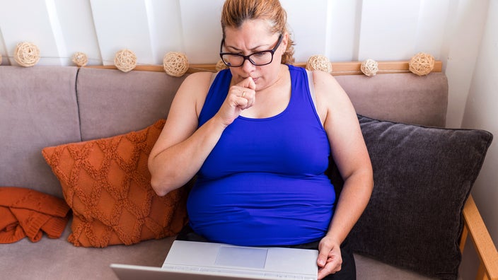 A woman does research on her laptop.