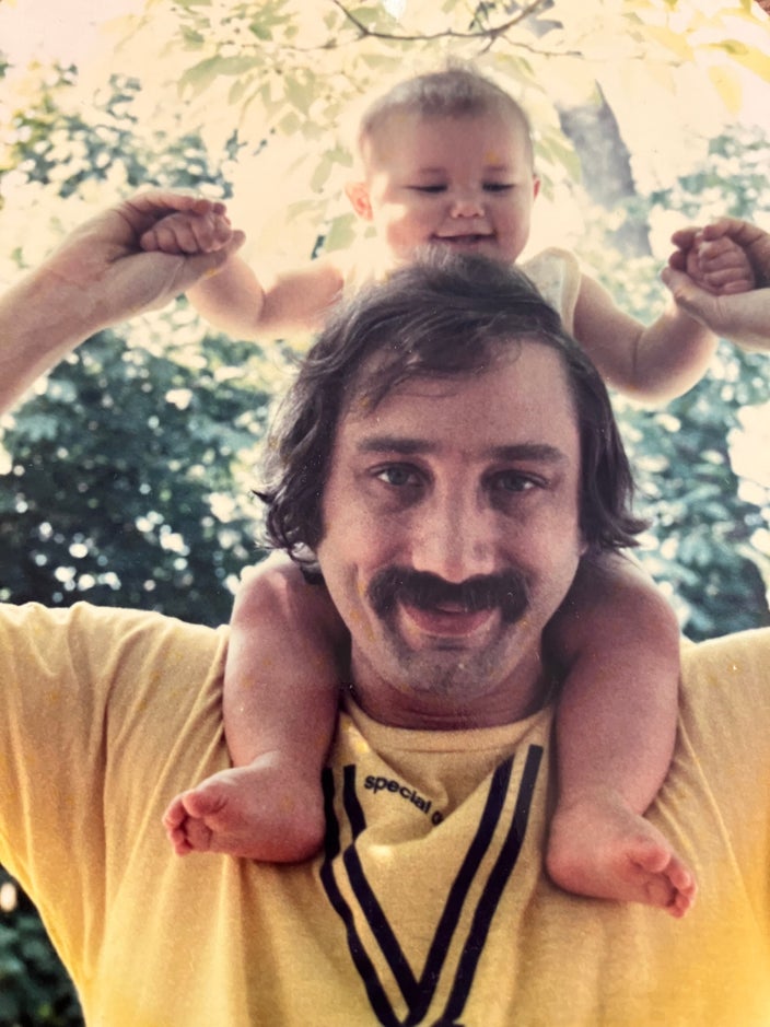 Ken Devoe is pictured at age 40 with his son on his shoulders.