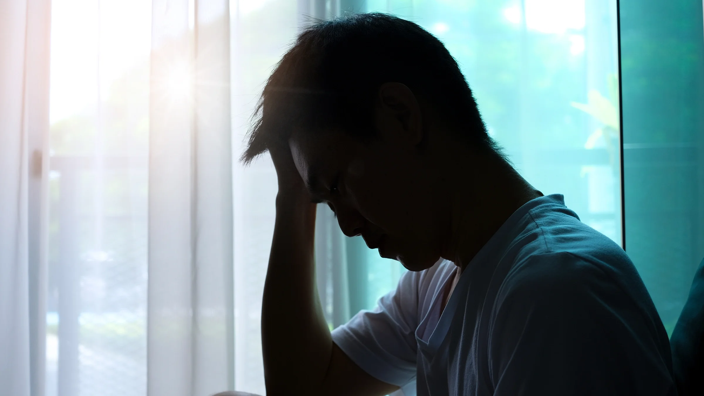 A silhouette of a man suffering from depression
