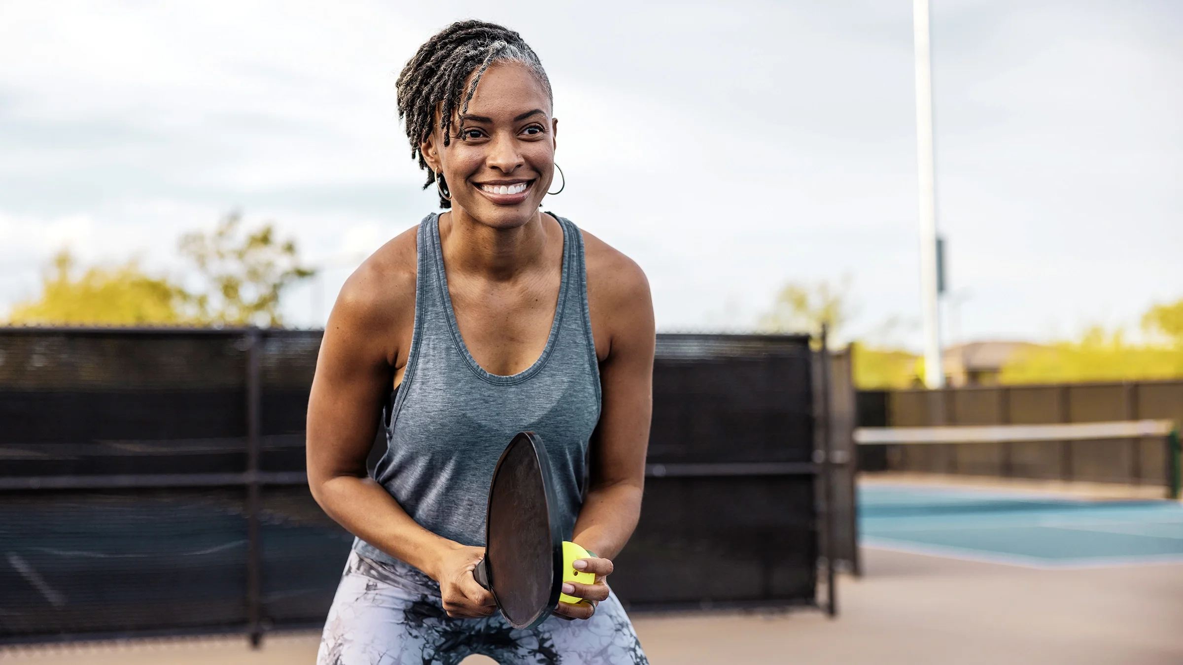 A woman prepares to serve the ball during a pickleball match.