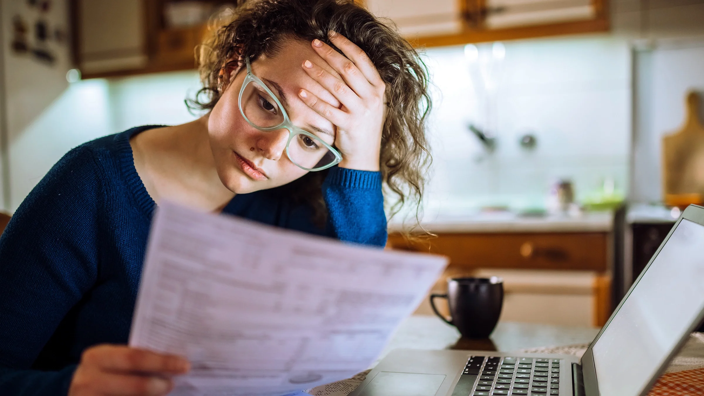 A woman is reading financial paperwork.
