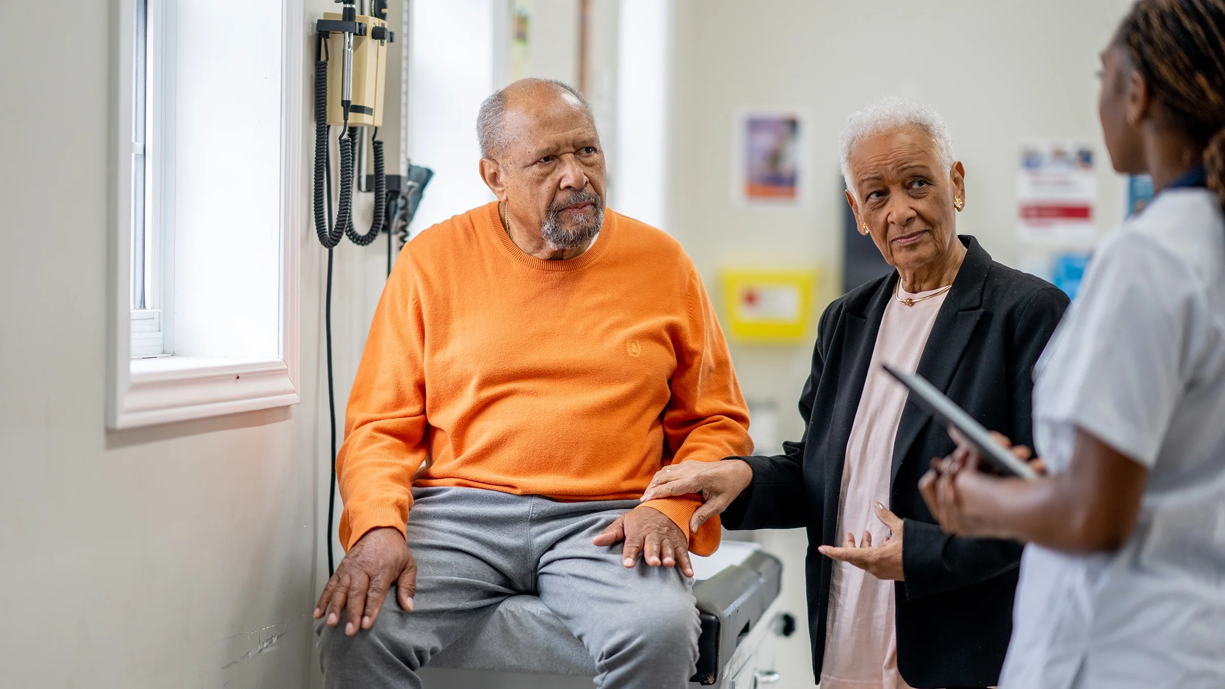 A man listens to a healthcare professional during a medical appointment.