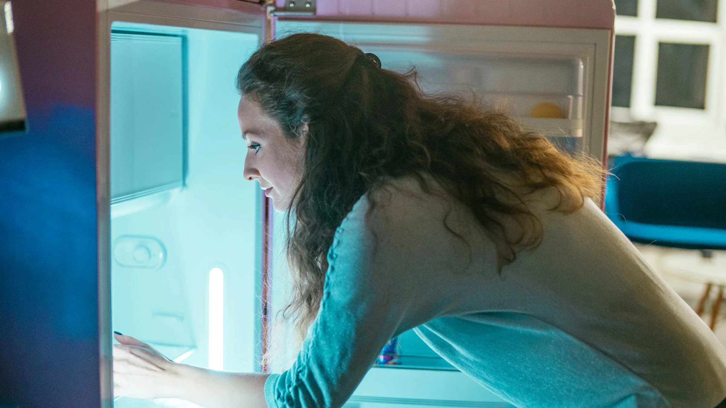 A person placing an item in their fridge.