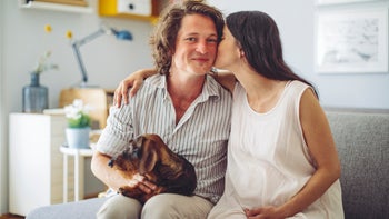 Pregnancy: Cost: couple pregnant holding belly and dog 1159446382