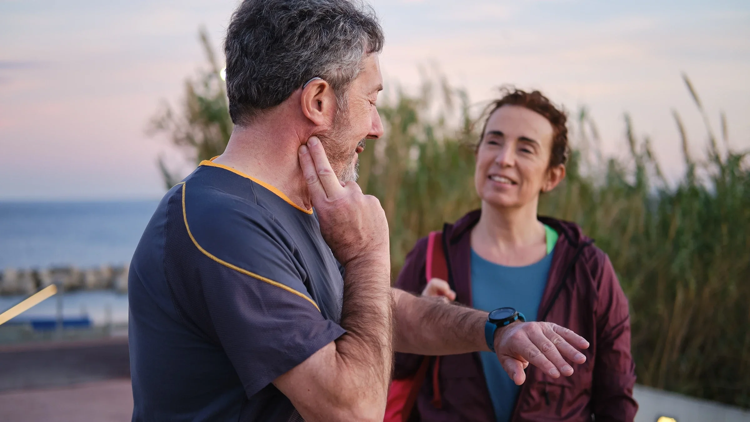 A man looks at his smartwatch to check his heartbeat while exercising outdoors.