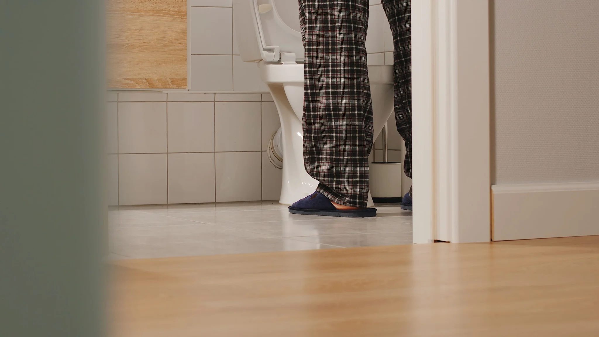 Adult man using toilet at home.