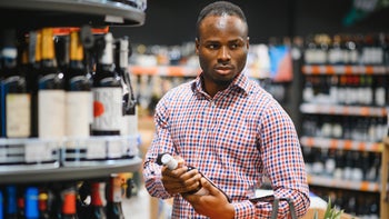 Alcohol: man buying wine in supermarket 1822641336