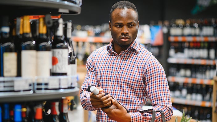 A man shops for wine at a supermarket.