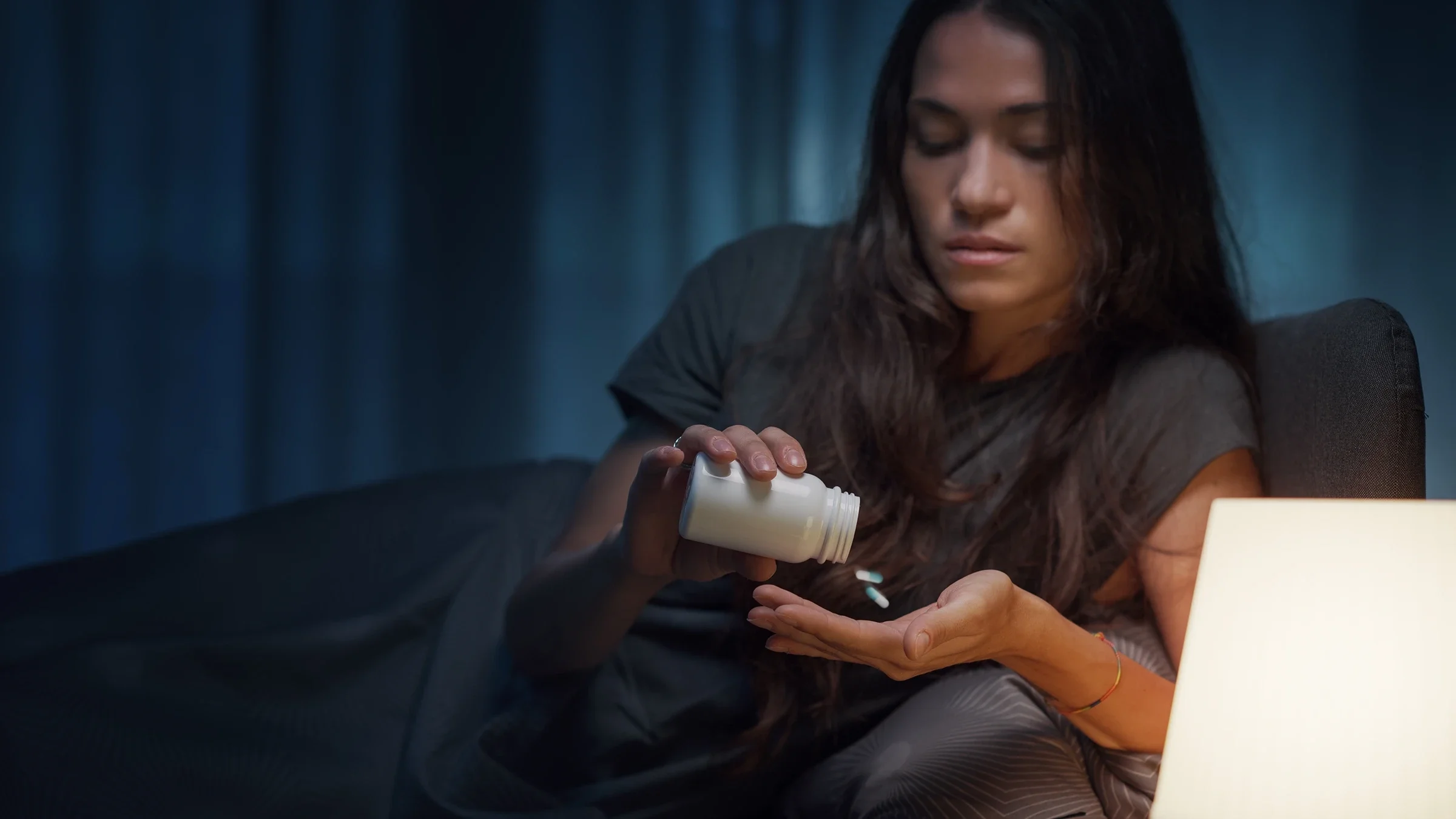 A woman is taking medication before bed.