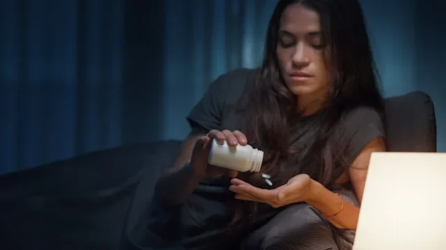 Medication basics: woman taking medication from nightstand 2204494844