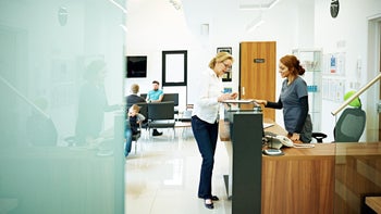 Health: Dental care: woman at dental receptionist desk 574878335