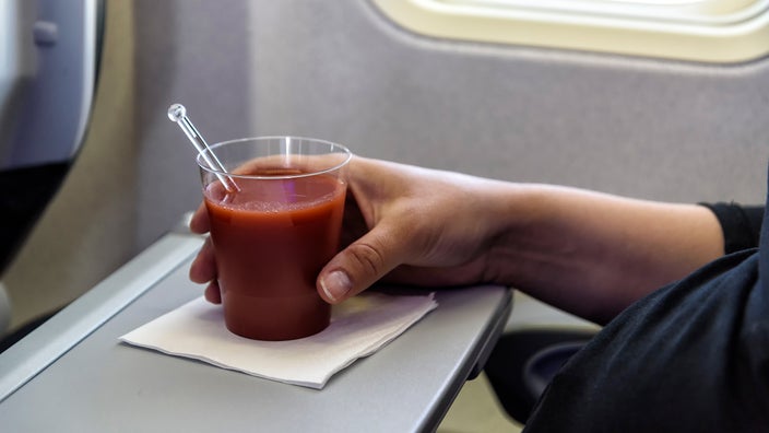 Close-up glass of tomato juice on airplane table.