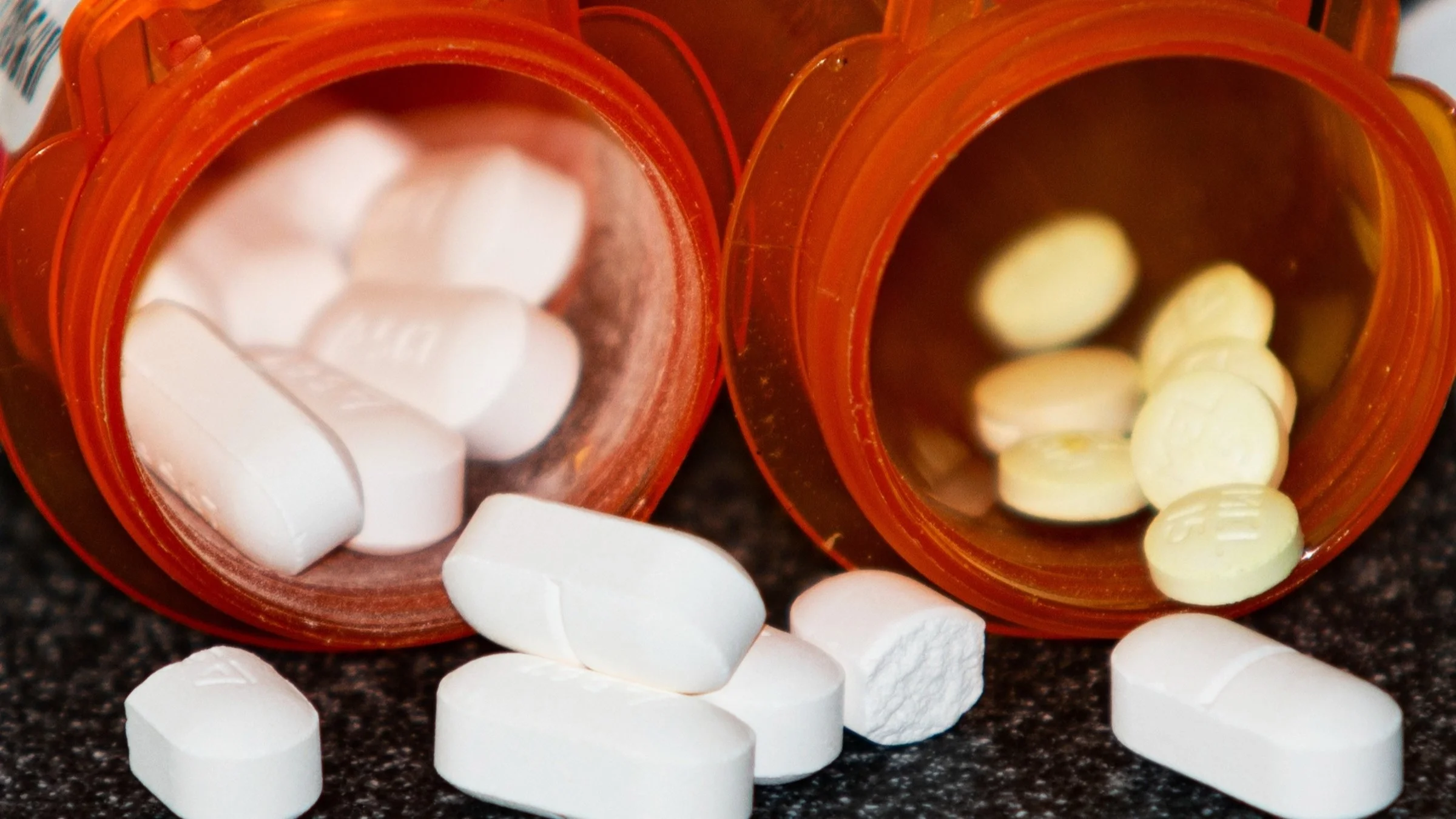 Two open pill bottles next to each other.