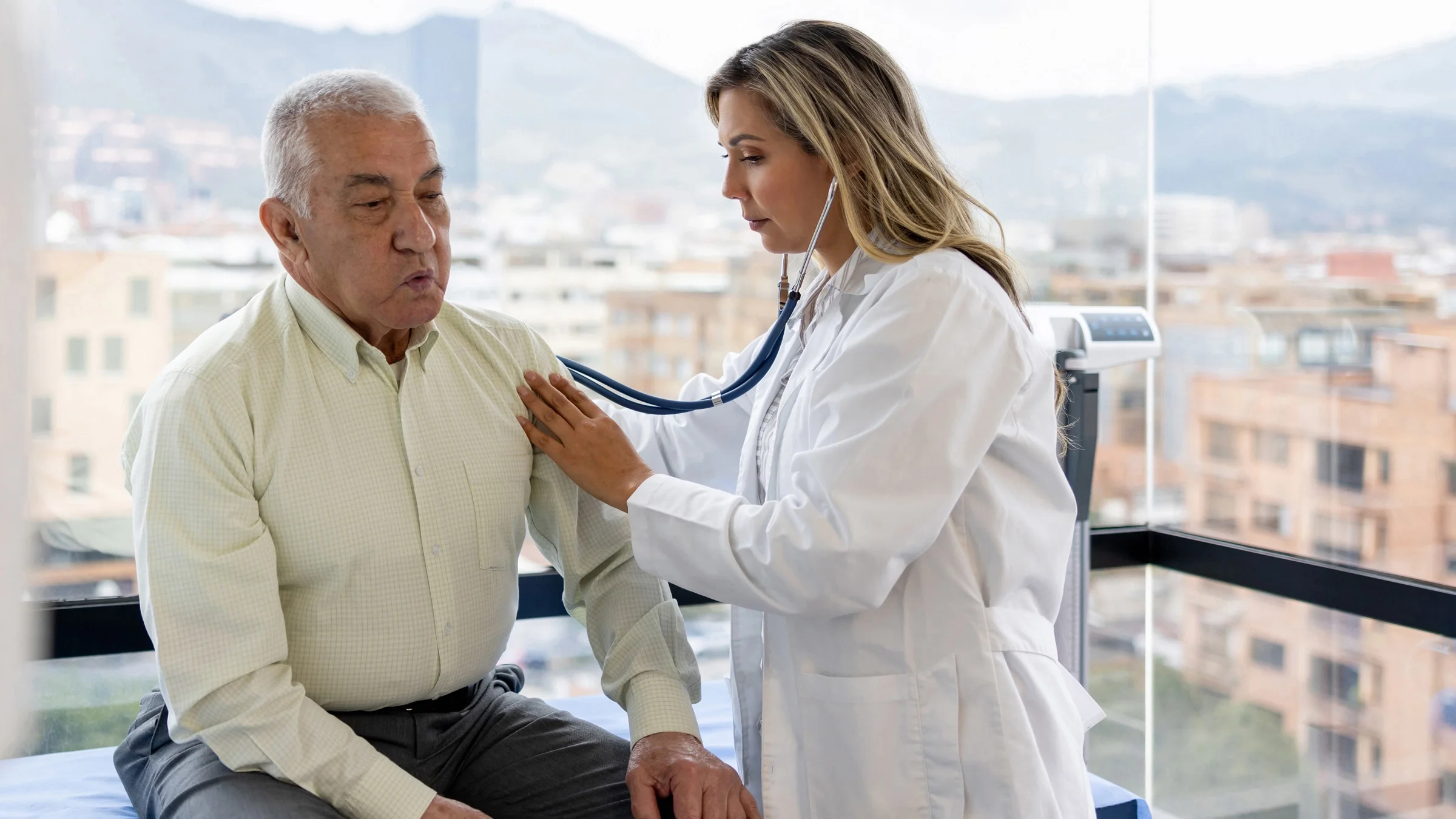 A doctor listening to a patient's heartbeat with a stethoscope.