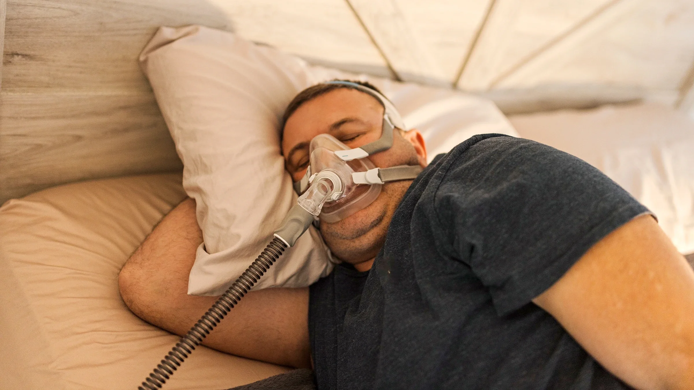 Man sleeping with a CPAP machine mask on for sleep apnea