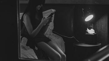 Behavioral addiction: Social media: person-on-phone-in-bed-b&w-1360742731