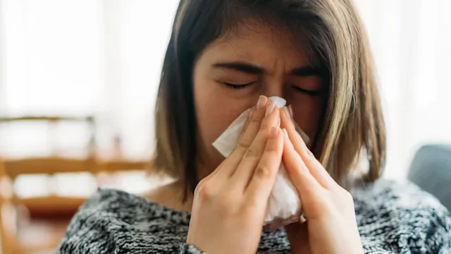 Allergic-rhinitis: woman blowing her nose 1125386303