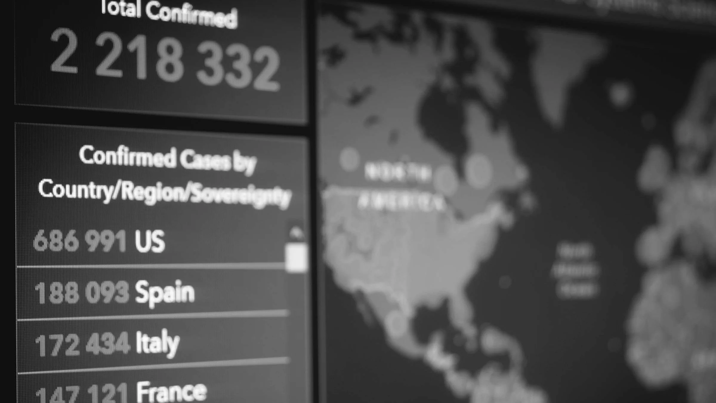 Close-up on a computer screen that has the total number of COVID-19 cases across the world. Half of the screen is the numbers and the other half is a map of the world.