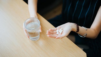 Health: Medication education: woman pills in hand 1157500098