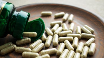 supplements herbs: closeup green pill bottle 975647240