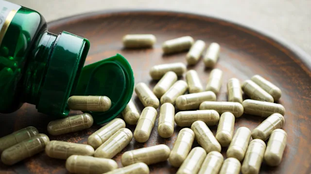 supplements herbs: closeup green pill bottle 975647240