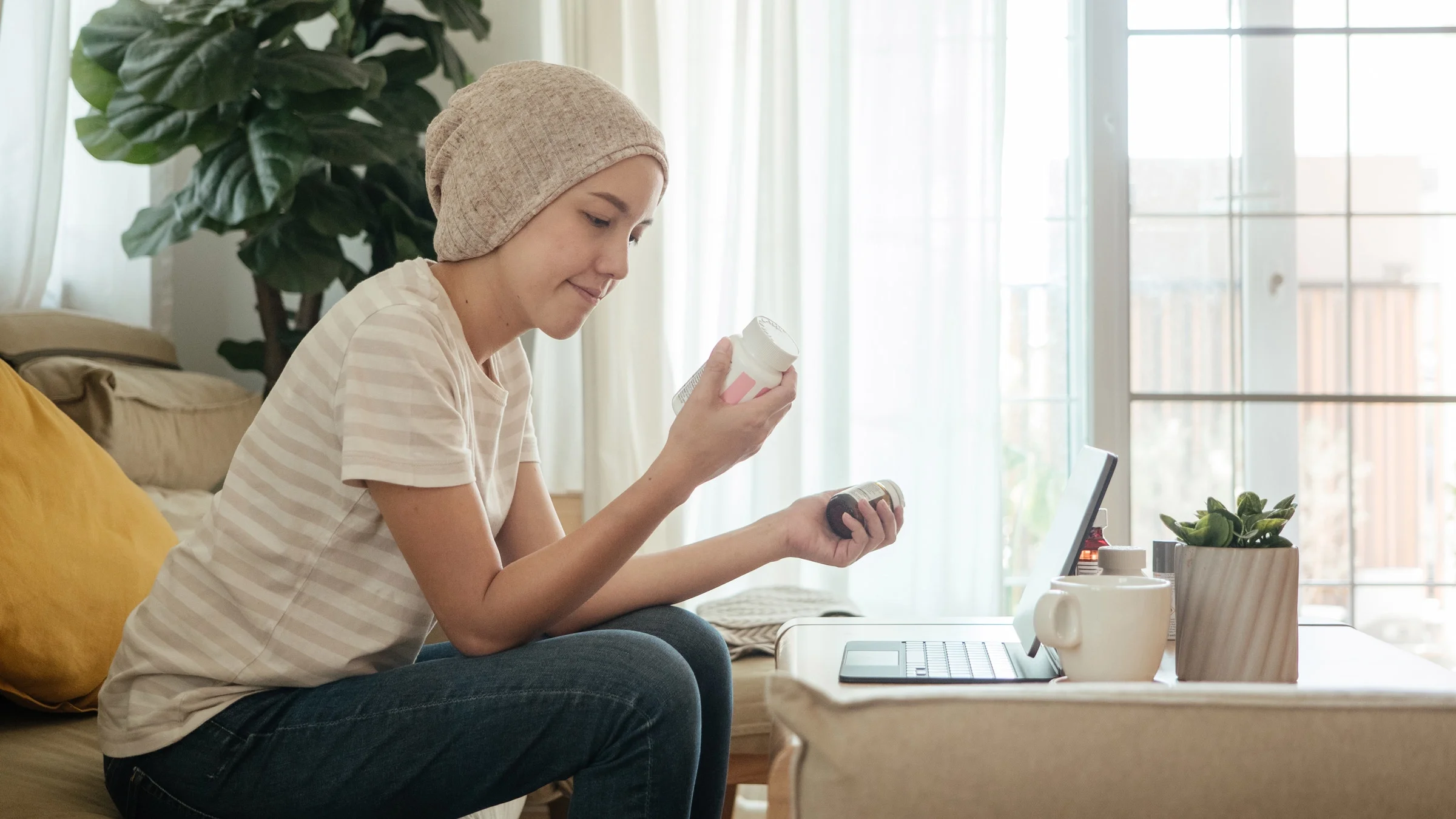 A cancer patient examining pill bottles on a telehealth call.