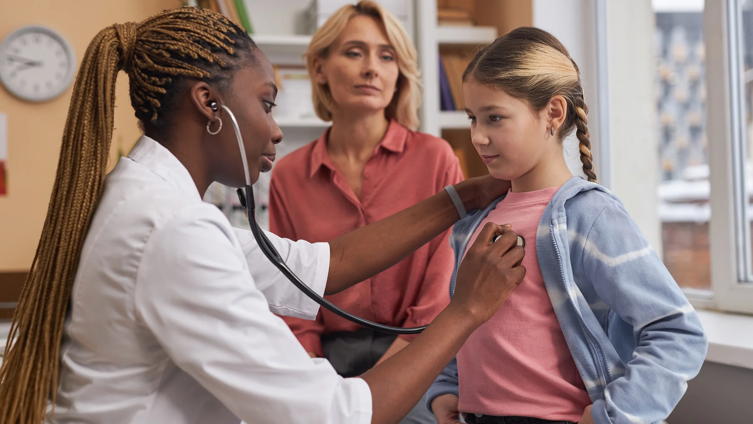 A doctor uses a stethoscope to listen to a child’s breathing.