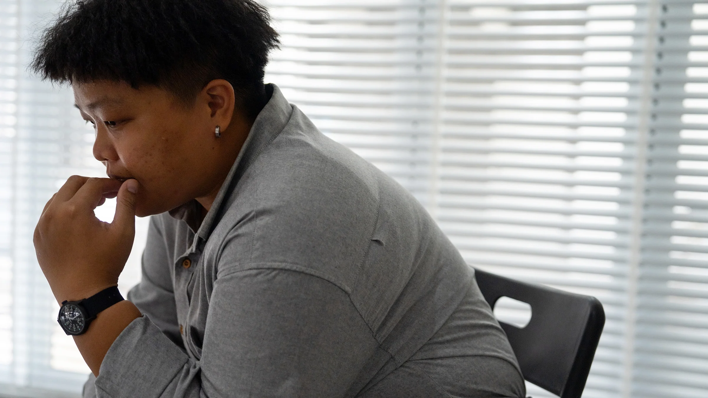 A person sits in a chair looking worried.